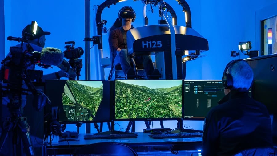 An instructor at the operating station, with a pilot flying the H125 VR simulator behind him